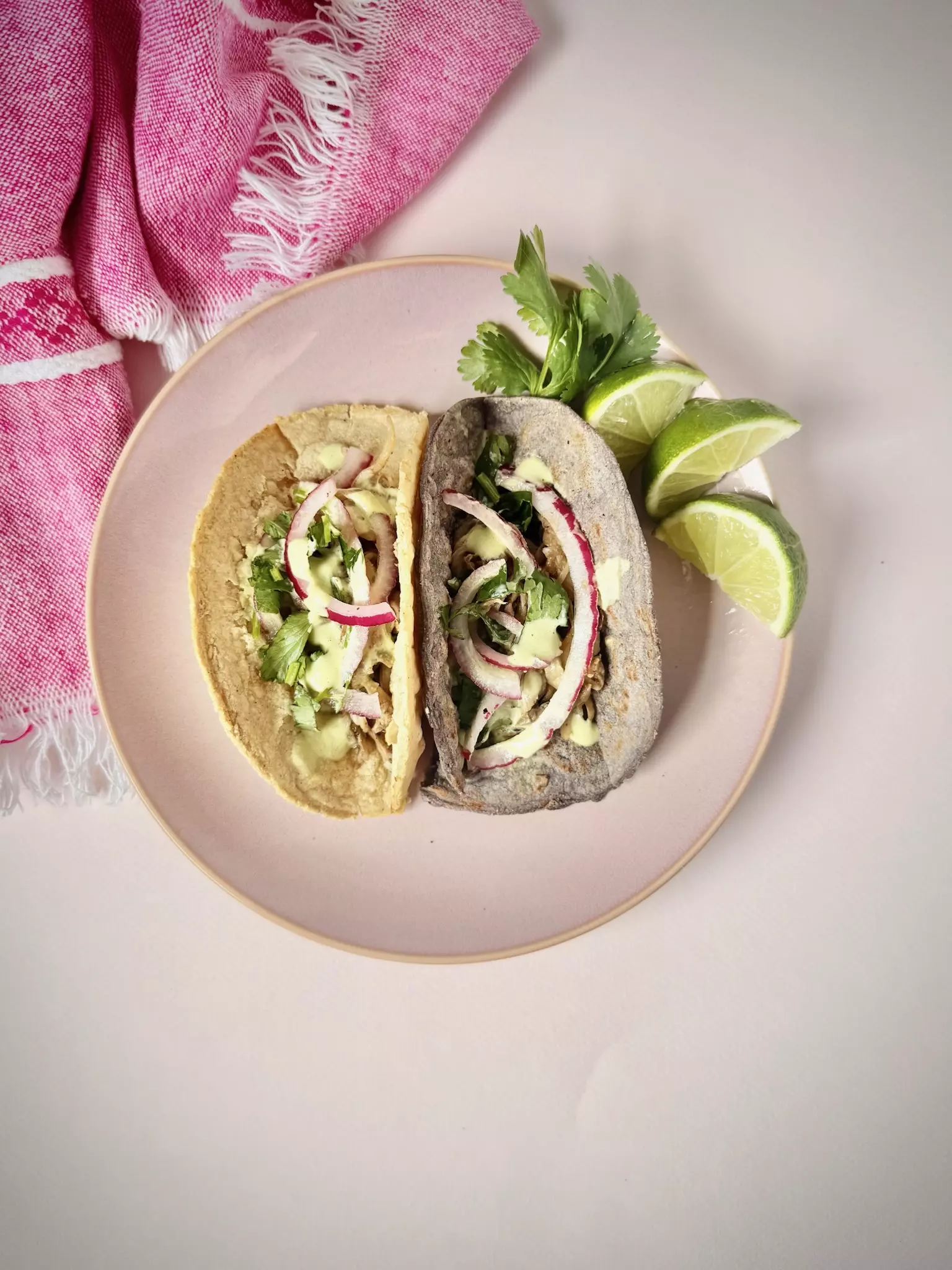 two oyster mushroom tacos with fixings and lime to the side